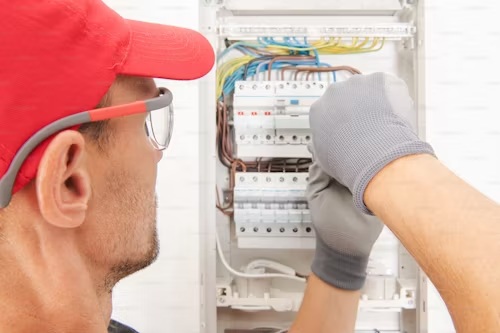 électricien vissant un coffret
